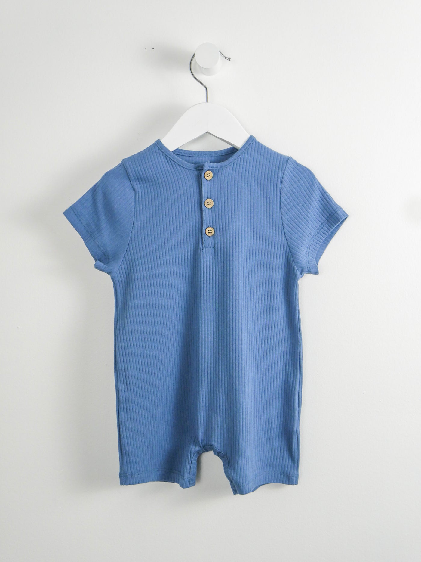 Organic cotton blue romper with snap closures around legs and 3 functional button down the front.