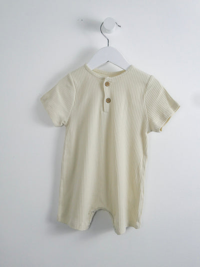 Organic cotton beige romper with snap closures around legs and 3 functional buttons down the front